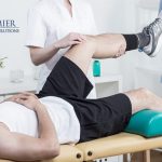 Physical therapist performing leg exercises on a patient at Premier Therapy Solutions clinic.
