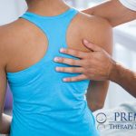 Person receiving shoulder therapy at a clinic, emphasizing physical rehabilitation and care.