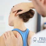 Physical therapist helping woman with neck pain at Premier Therapy Solutions.