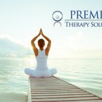 Woman meditating on dock at sunrise, promoting Premier Therapy Solutions.