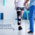 Person with knee brace using crutches in a physical therapy session at Premier Therapy Solutions.