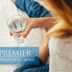Woman holding a glass of water, promoting Premier Therapy Solutions' health and wellness services.