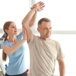 physical therapist working on patients arm