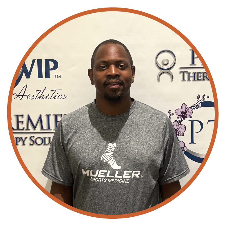 24 Man in a Mueller Sports Medicine shirt standing in front of a white backdrop with company logos.