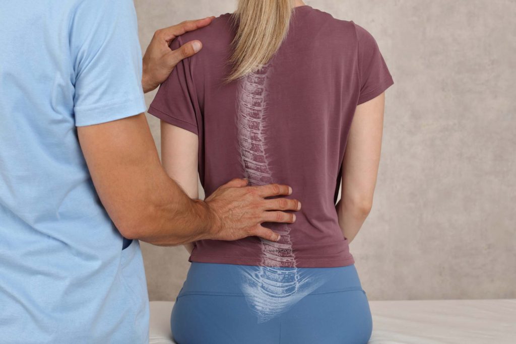 Physical therapist assisting scoliosis patient with spine therapy, highlighting spinal alignment and back pain relief techniques. - Premier Therapy Boca Raton Physical therapist assisting scoliosis patient with spine therapy, highlighting spinal alignment and back pain relief techniques.