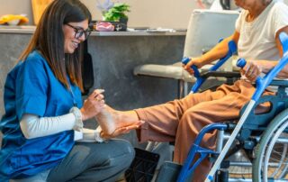 Healthcare professional evaluating a patient’s leg mobility during a physiotherapy session
