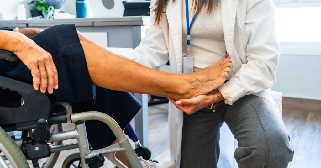 Physiotherapist assisting an elderly patient in a wheelchair during mobility therapy