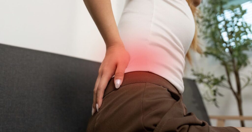 Woman pressing her hip with a red highlighted pain area indicating inflammation or joint discomfort.