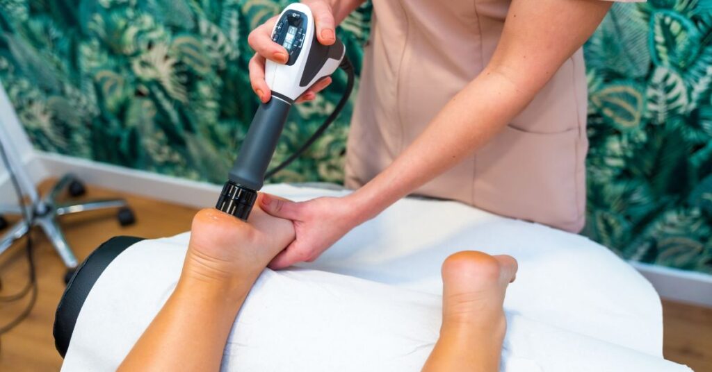 Deep tissue laser therapy being used on a patient’s foot to treat pain and inflammation.