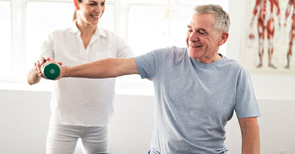 Physical therapist guiding senior patient through manual therapy and strength exercise for chronic pain